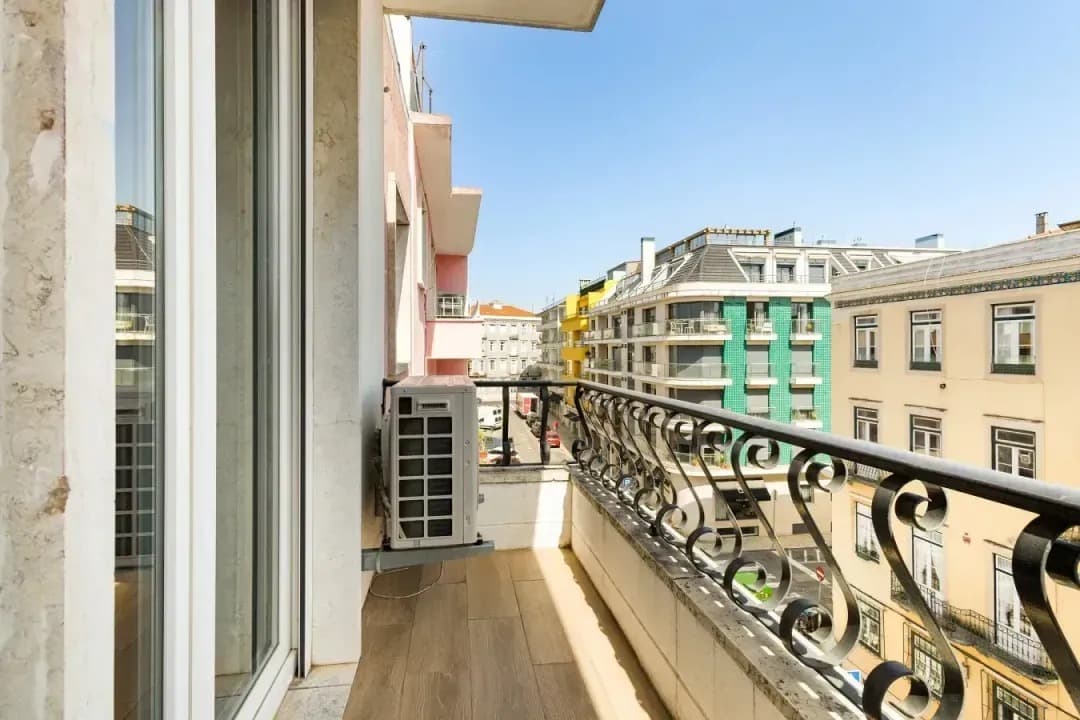 Varanda com vista para uma rua de Campo de Ourique com edifícios coloridos