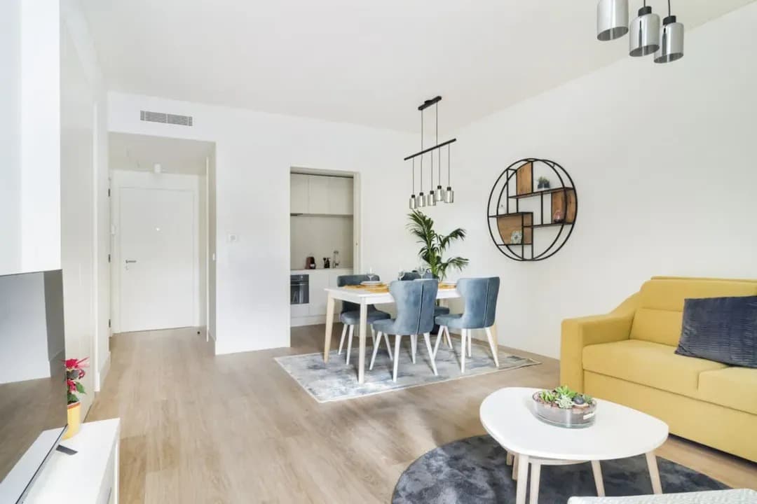 Sala de estar e jantar luminosa com sofá amarelo no apartamento Ribeira Garden